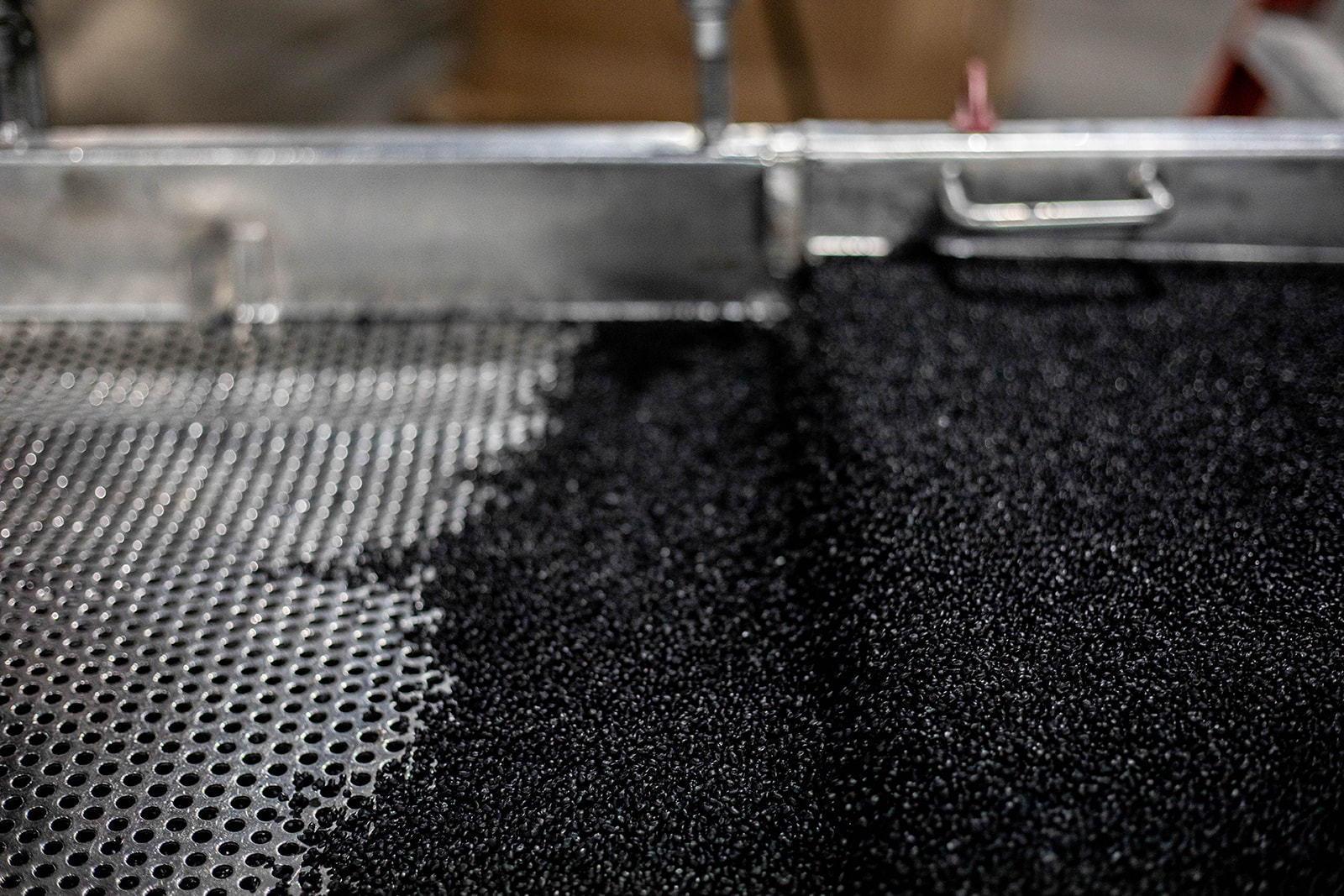 Close-up of black PP pellets emerging from PRI compounding line